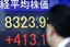 A businessman looks at an electronic stock board of a securities firm in Tokyo, Japan, showing the benchmark Nikkei 225 stock average surged 413.14 points, or 5.22 percent, to 8,323.93 Tuesday, Nov. 25, 2008.