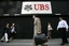 In this April 25, 2008 file picture, pedestrians pass an UBS office building in New York.