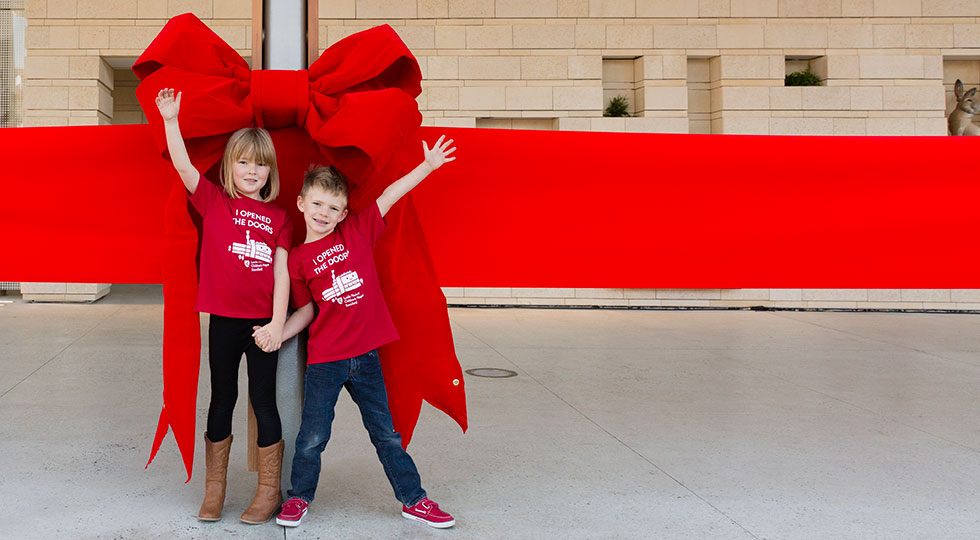 Lucile Packard Chldren's Hospital Stanford grand opening December 9, 2017, young patients wearing their "I opened the doors" t shirts in front of the large red ribbon