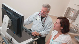 Photo of a doctor working on a library computer